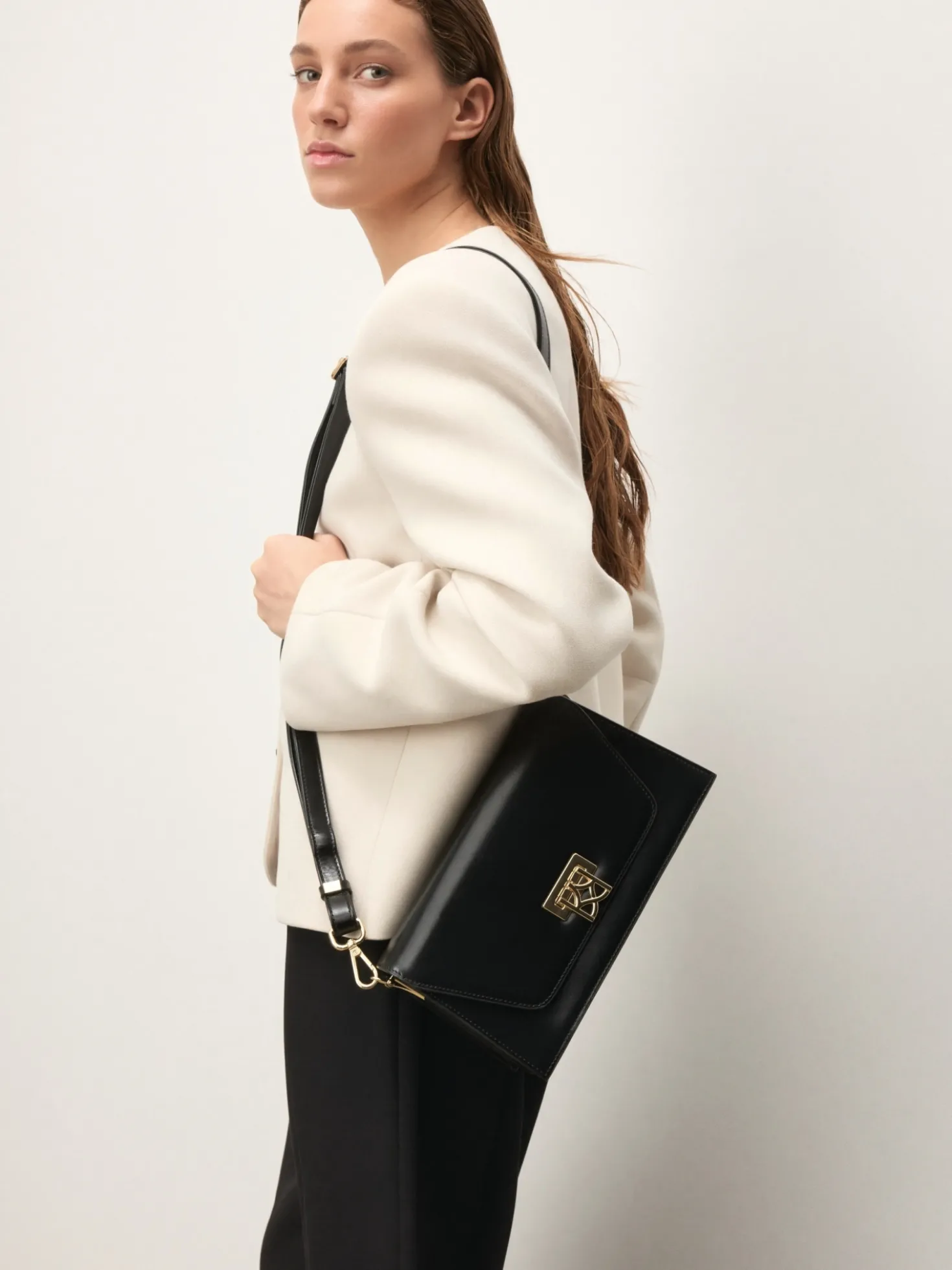 Elegancka mała torebka z klapą zamykaną ozdobnym monogramem